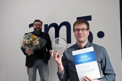Nils Asmussen hält den preis für seine Dissertation